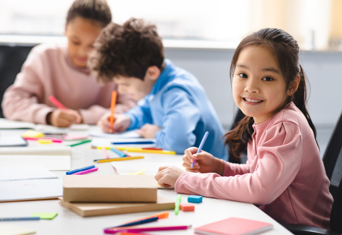 Young students engaged in drawing and writing activities at an international school